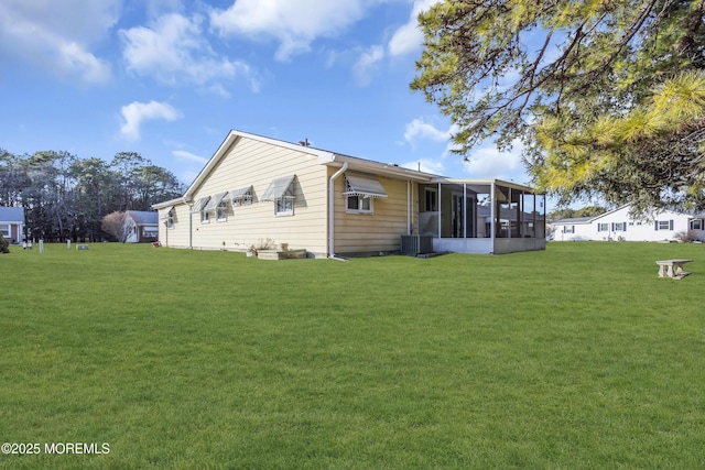 back of property featuring a sunroom, cooling unit, and a lawn