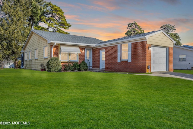 ranch-style house with a garage and a lawn