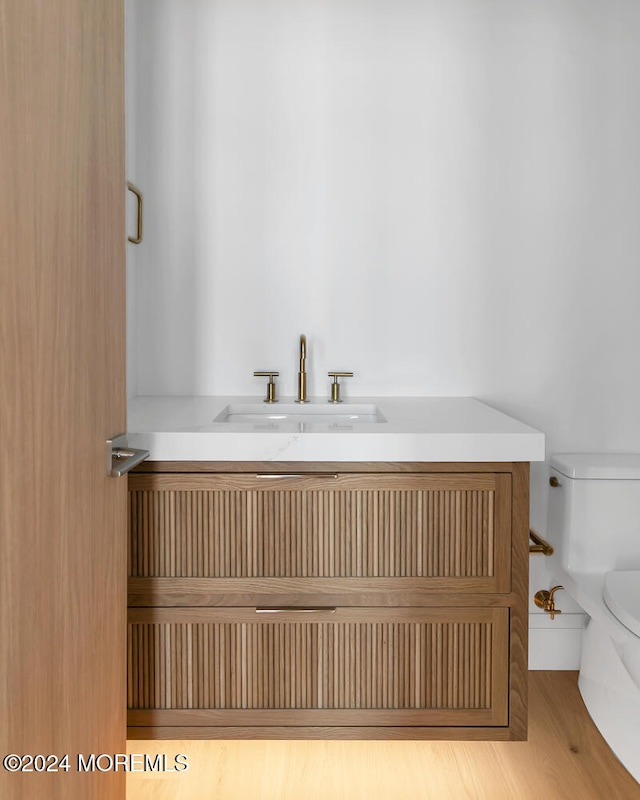 bathroom with vanity, toilet, and hardwood / wood-style floors