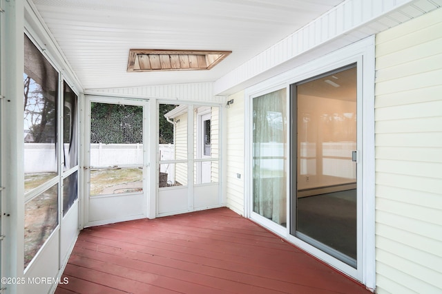 unfurnished sunroom with vaulted ceiling and a baseboard heating unit