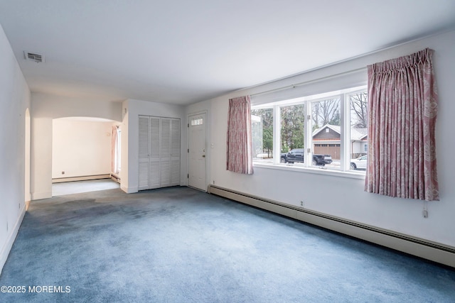 unfurnished room featuring a baseboard heating unit and carpet