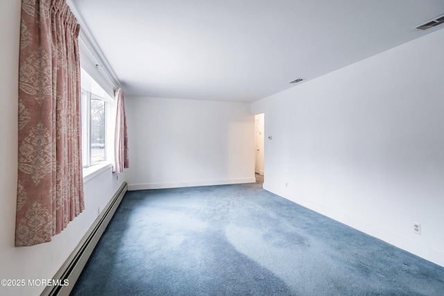 spare room featuring dark carpet and baseboard heating