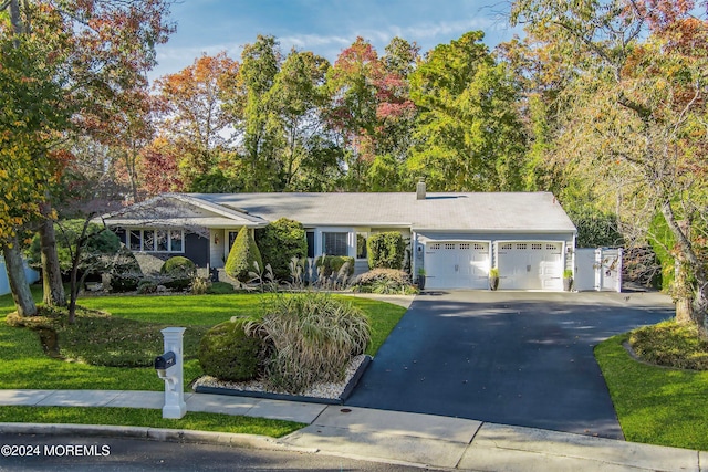 ranch-style home featuring a garage and a front yard