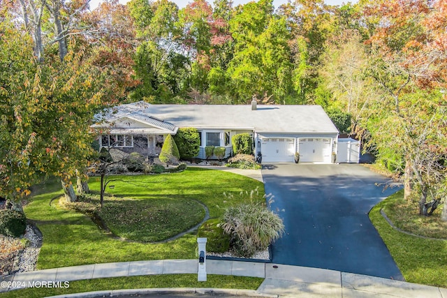 ranch-style home with a garage and a front lawn