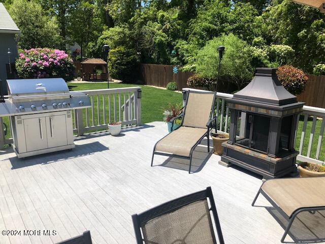 deck with a gazebo, area for grilling, and a lawn