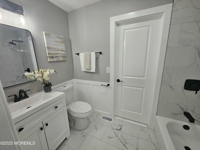 full bathroom with vanity, tiled shower / bath combo, and toilet