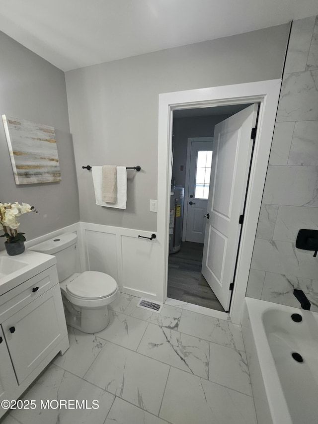 full bathroom featuring water heater, vanity, shower / bathing tub combination, and toilet