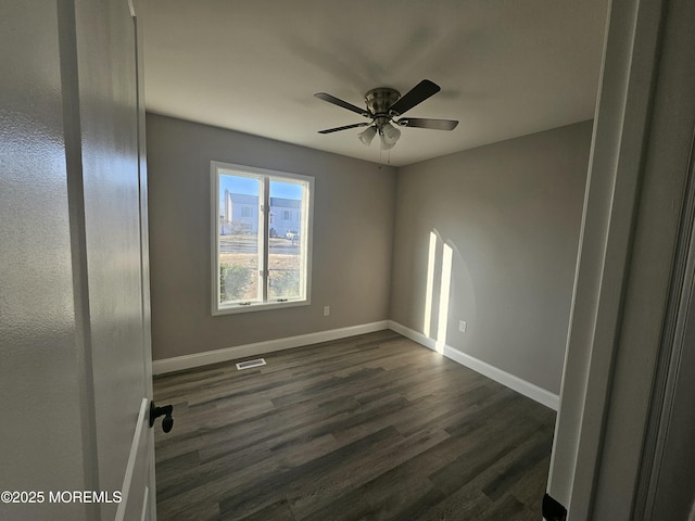 unfurnished room with dark hardwood / wood-style flooring and ceiling fan