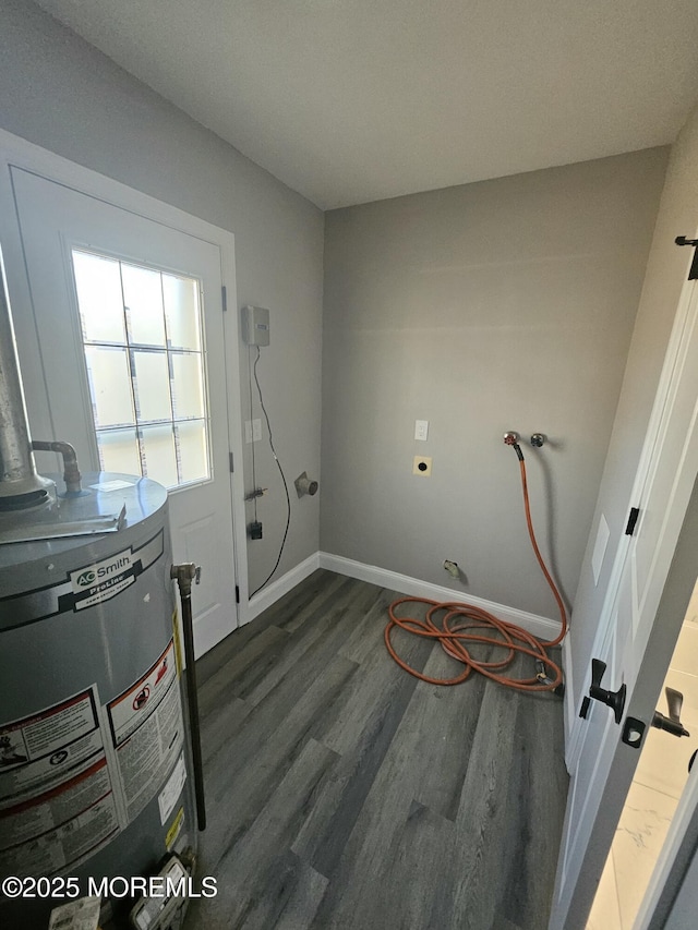 washroom with water heater, hookup for a washing machine, dark hardwood / wood-style floors, and electric dryer hookup