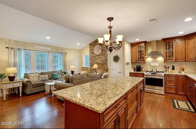 kitchen featuring a kitchen island, dark hardwood / wood-style floors, lofted ceiling, wall chimney range hood, and stainless steel range with gas stovetop