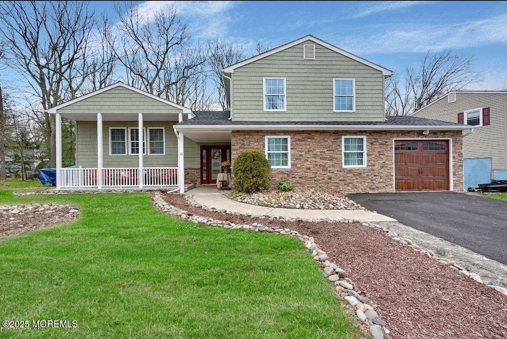 view of front of house with a garage, a front yard, and covered porch