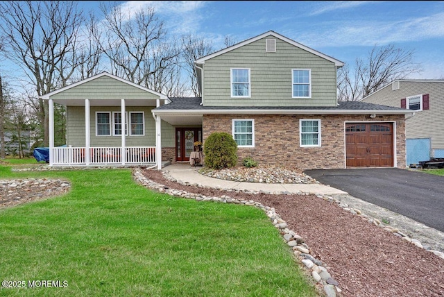 view of front of house with a garage, a front yard, and covered porch