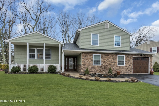 view of front of house with a garage, covered porch, and a front yard