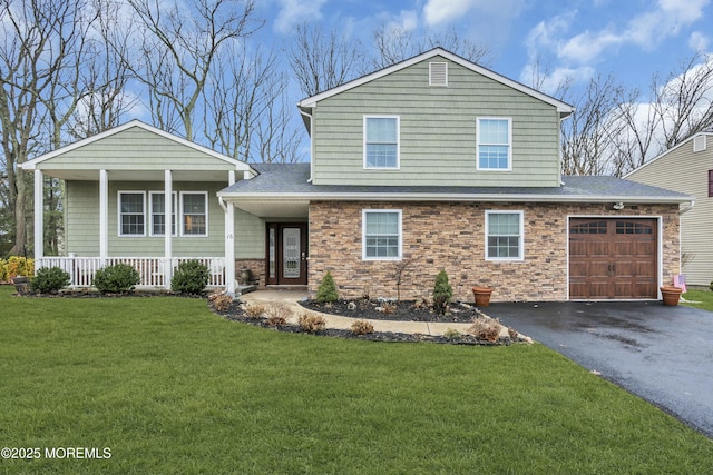 view of front of house featuring a garage, a front yard, and a porch