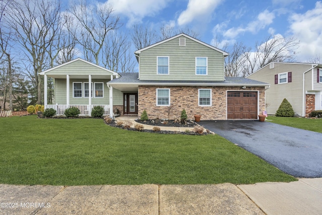 split level home featuring a garage, covered porch, and a front lawn