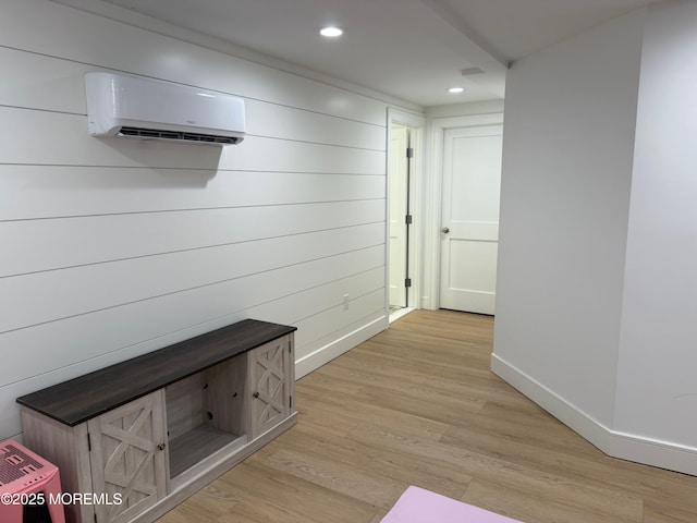 mudroom with light wood-type flooring and an AC wall unit