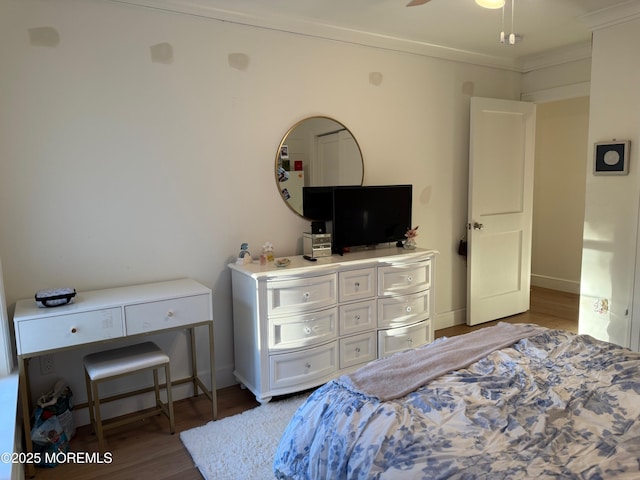 bedroom with ornamental molding, dark hardwood / wood-style floors, and ceiling fan