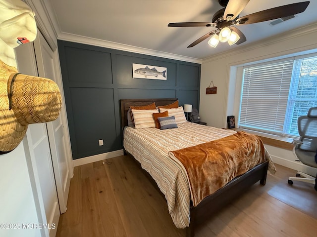 bedroom featuring dark hardwood / wood-style flooring, crown molding, and ceiling fan