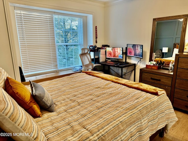 bedroom with crown molding and light wood-type flooring