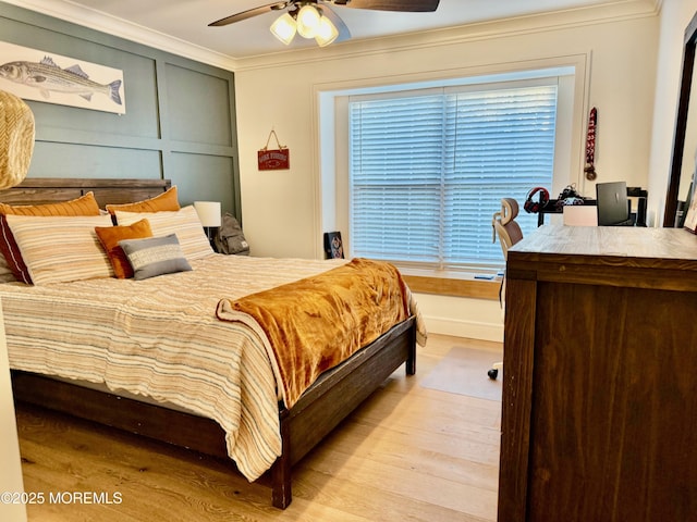 bedroom featuring multiple windows, ornamental molding, ceiling fan, and light hardwood / wood-style floors