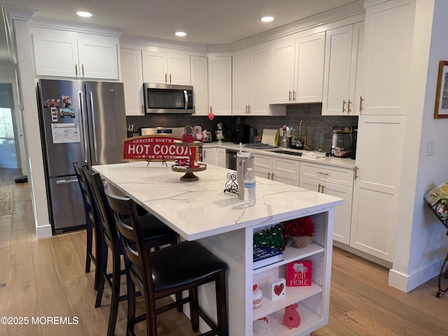 kitchen with white cabinetry, sink, and stainless steel appliances