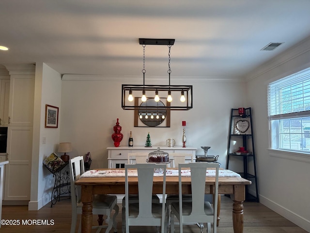 dining space featuring wood-type flooring and ornamental molding