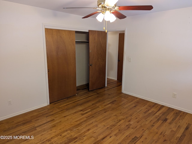 unfurnished bedroom featuring ceiling fan, dark hardwood / wood-style flooring, and a closet