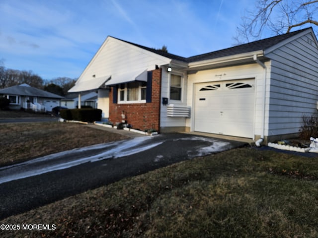 view of side of property with a garage and a lawn