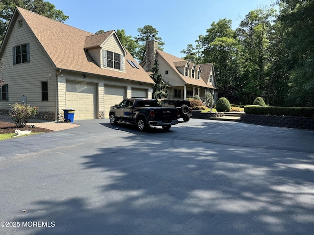 cape cod-style house featuring a garage