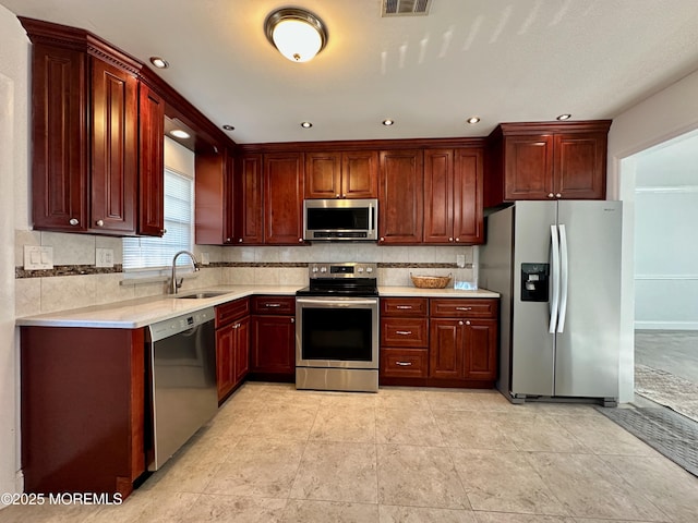 kitchen featuring stainless steel appliances, sink, and decorative backsplash