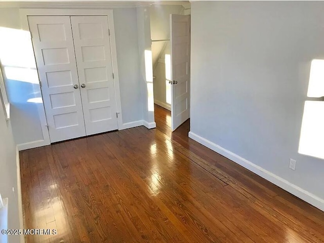 unfurnished bedroom featuring dark hardwood / wood-style floors and a closet