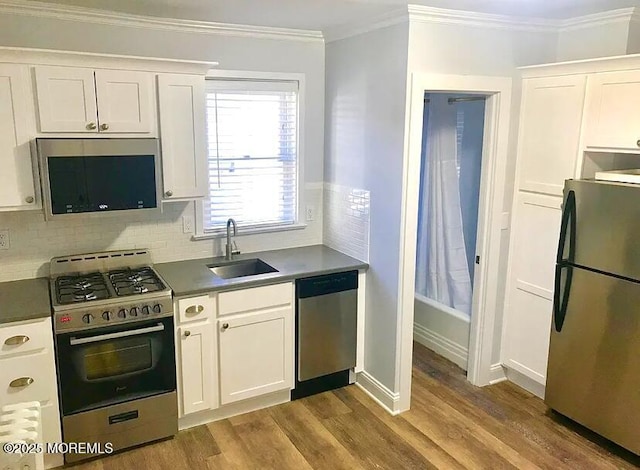 kitchen with crown molding, appliances with stainless steel finishes, sink, and white cabinets