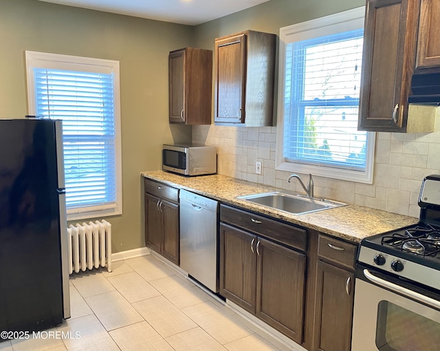 kitchen with stainless steel appliances, radiator, sink, and dark brown cabinets