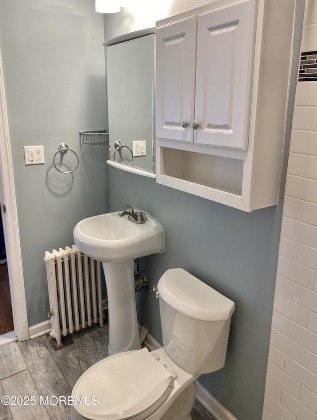 bathroom featuring radiator heating unit and toilet