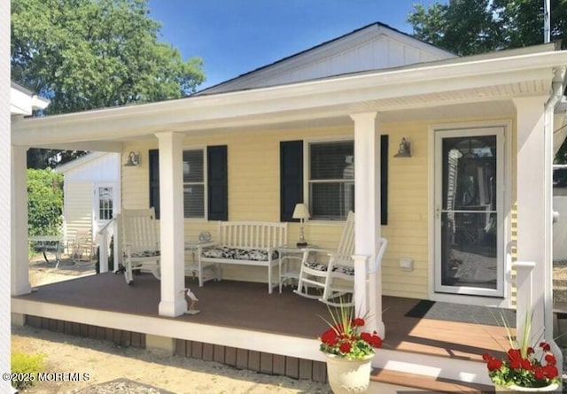 rear view of property featuring covered porch