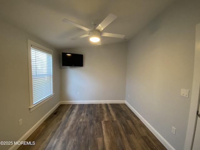 empty room featuring ceiling fan and dark hardwood / wood-style flooring