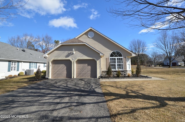 view of front of home featuring a garage, central AC unit, and a front lawn