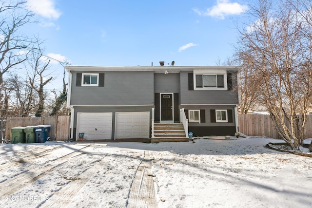 snow covered rear of property featuring a garage