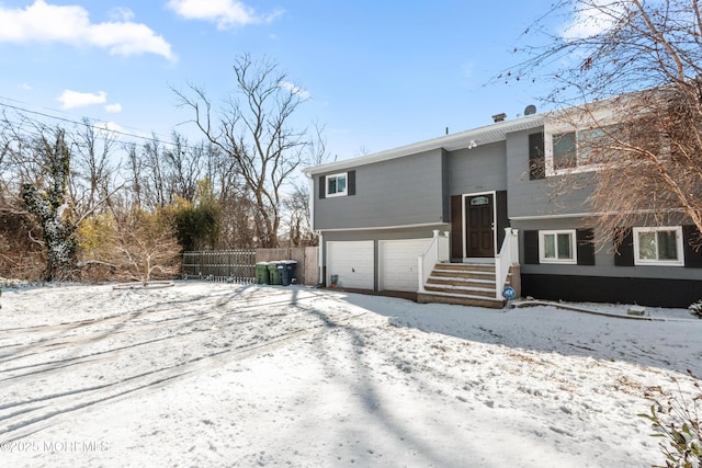 snow covered property featuring a garage