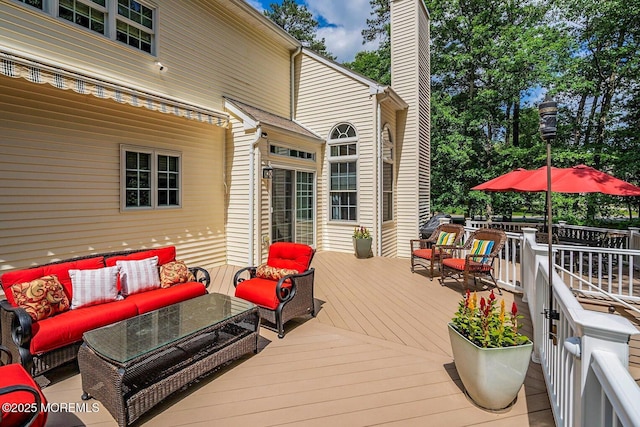 wooden terrace with an outdoor living space