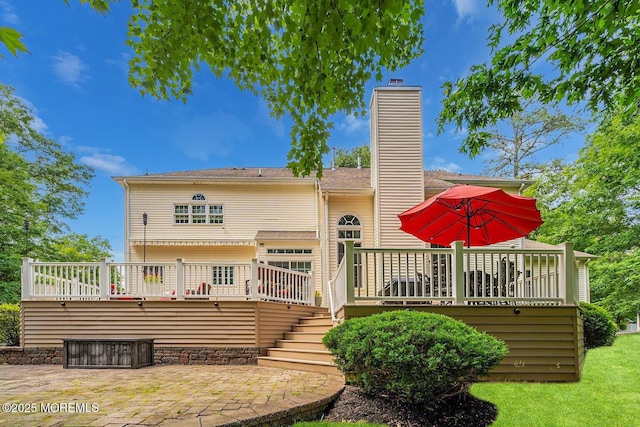 back of house featuring a deck and a patio area