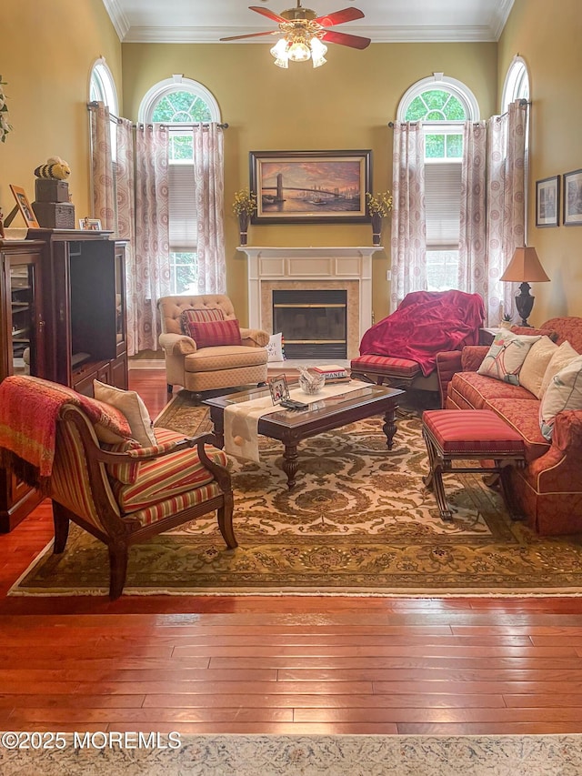 living room featuring hardwood / wood-style flooring, crown molding, and a wealth of natural light