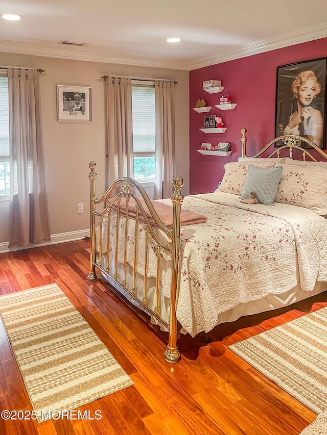 bedroom with hardwood / wood-style flooring and ornamental molding