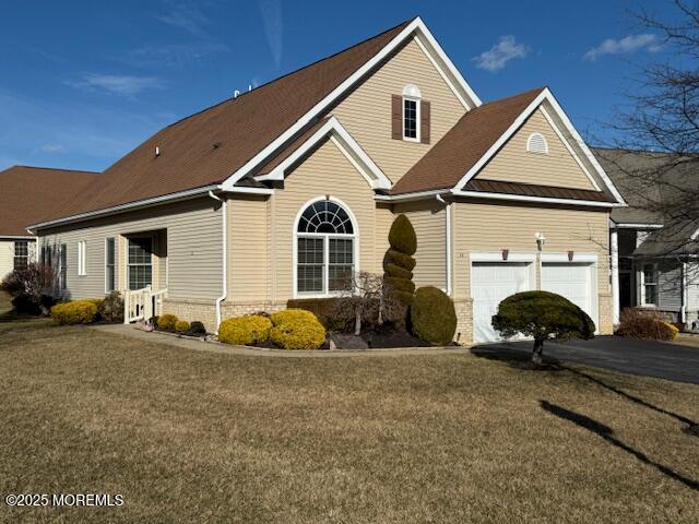 view of property featuring a garage and a front lawn