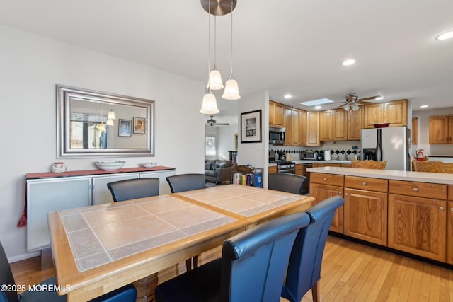 dining room with ceiling fan and light wood-type flooring