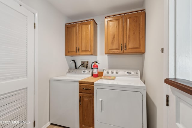 laundry room featuring washing machine and dryer and cabinets