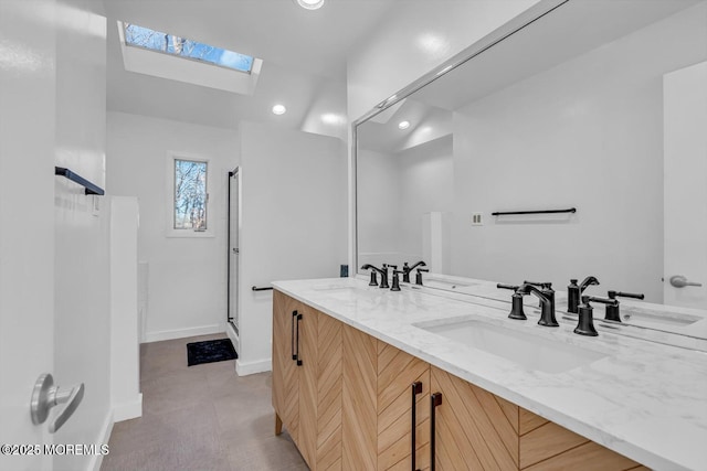 bathroom with vanity, lofted ceiling with skylight, and a shower with door