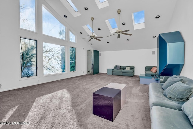 carpeted living room featuring ceiling fan, a skylight, and high vaulted ceiling