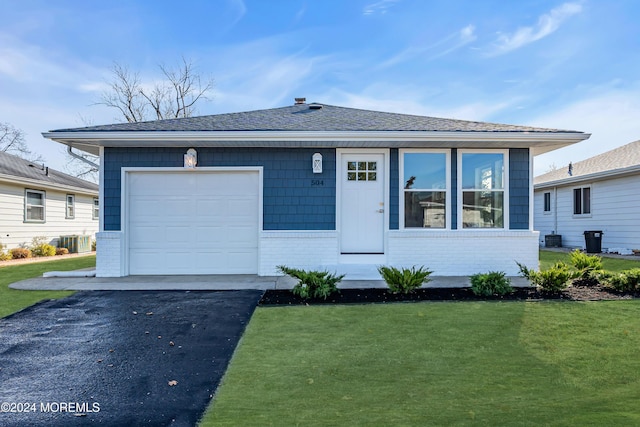 view of front of house featuring central AC, a garage, and a front yard