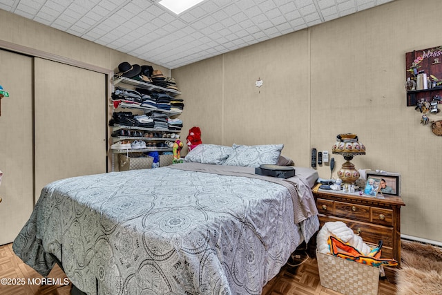 bedroom featuring parquet floors and a closet